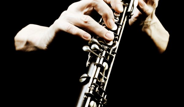 Oboe musical instrument of symphony orchestra. Oboist hands playing isolated on black. It's not clarinet, it's oboe! It is first instrument of classical orchestra.